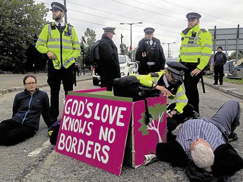 Chris being talked to by police officer while locked-on, 5 September 2017. PHOTO: NINA CARTER-BROWN